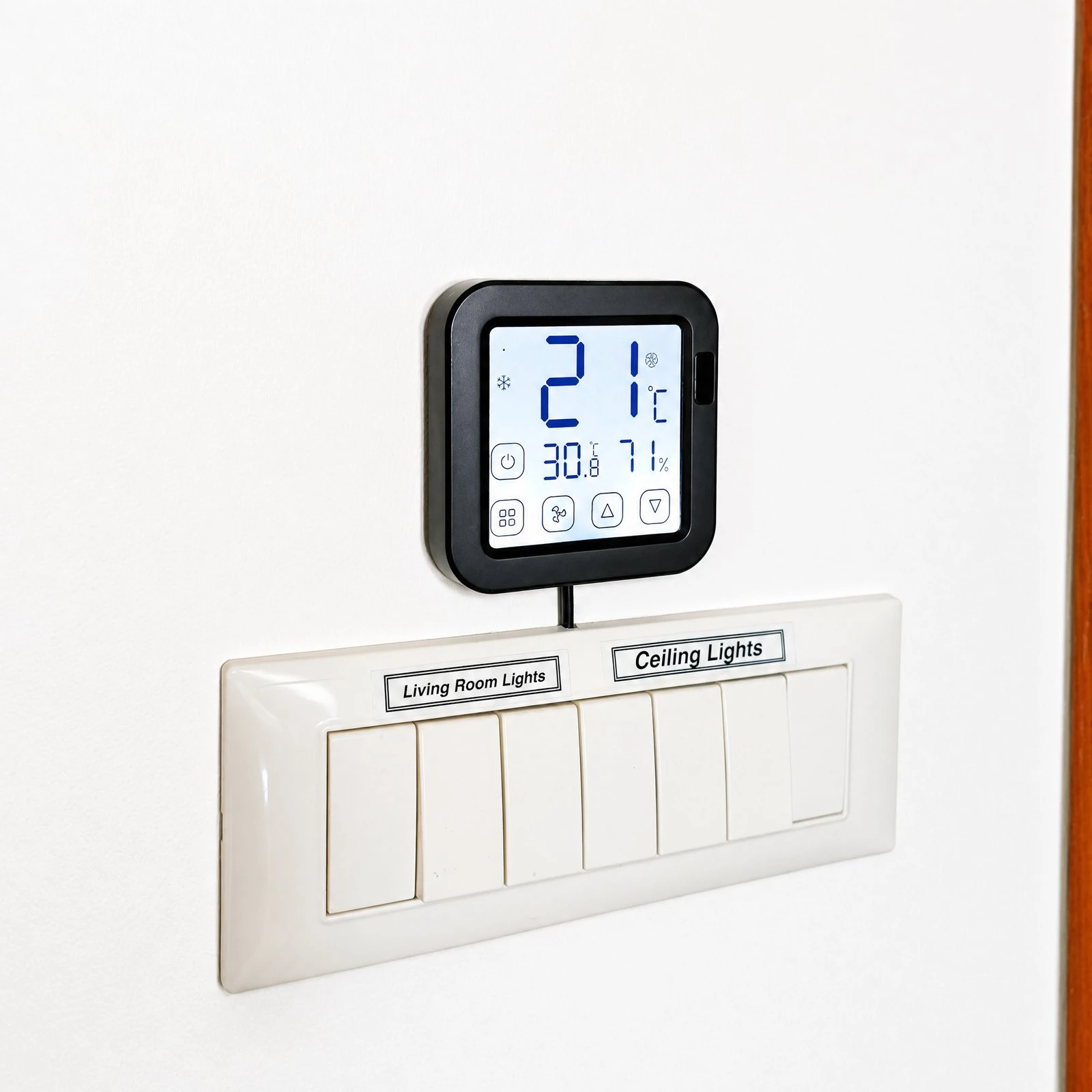 Termostato inteligente EcoHost instalado sobre interruptores en una pared blanca